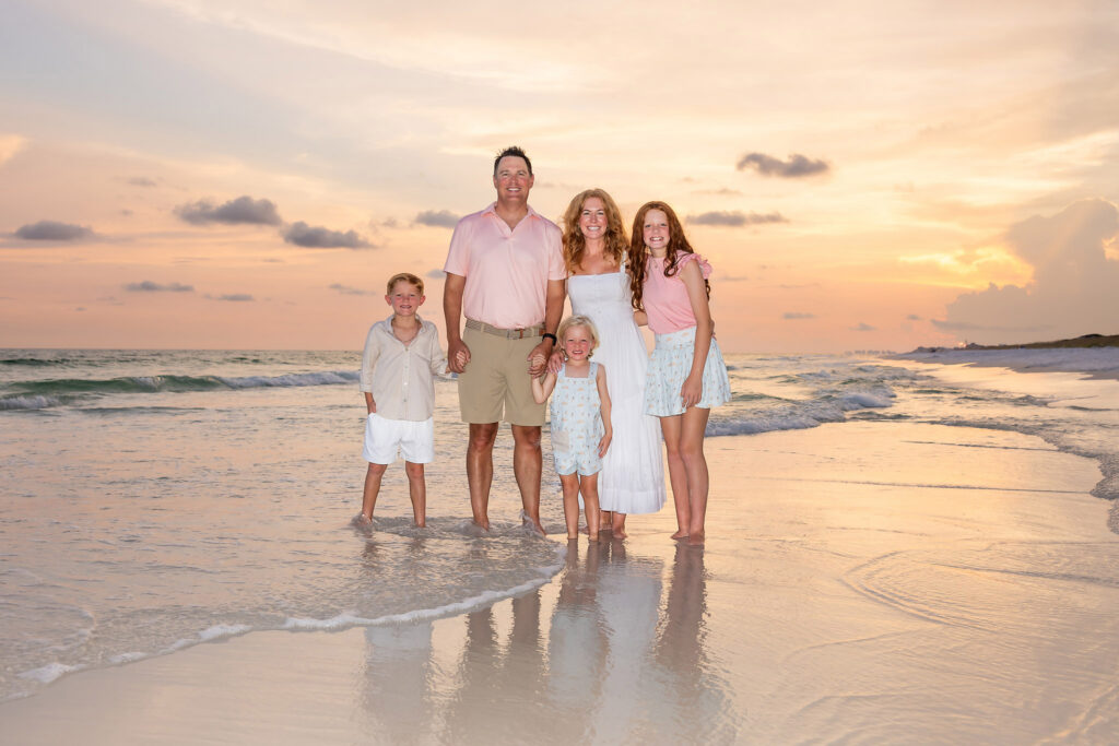 Sunset photo of a family of 5 wearing pinks and whites on the beaches of 30a.