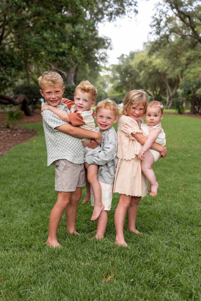 a cute photo of 5 young siblings wearing light earth tones in the park at Watercolor, florida on 30a.