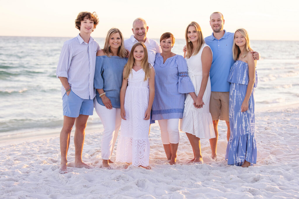 A family portrait of 8 wearing shades of blue on the beaches of 30a.