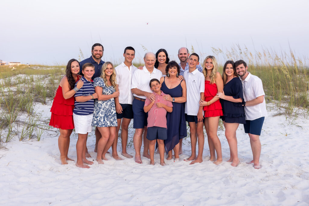 A multi-family portrait on the beaches of Destin while they are wearing red white and blue outfits.