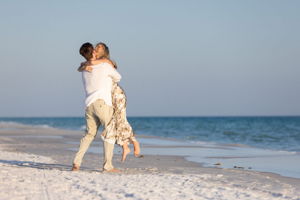 Man proposing to his partner on white sand beach along 30A Florida at sunset with ocean in background