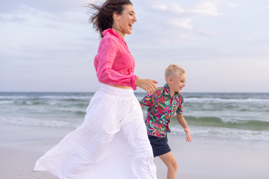 Mother and son running on beach together at Grayton Beach, Florida
